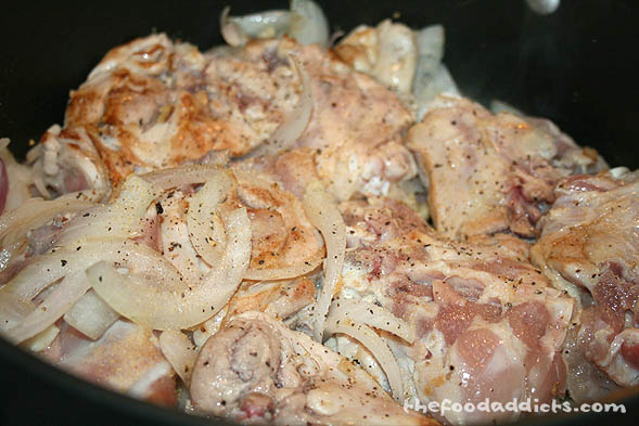 In a large cooking pot, start by browning some chopped garlic and onions. Then, add 8 pieces of skinless chicken thighs along with some garlic powder and pepper. Cover the pot and let the chicken brown up.